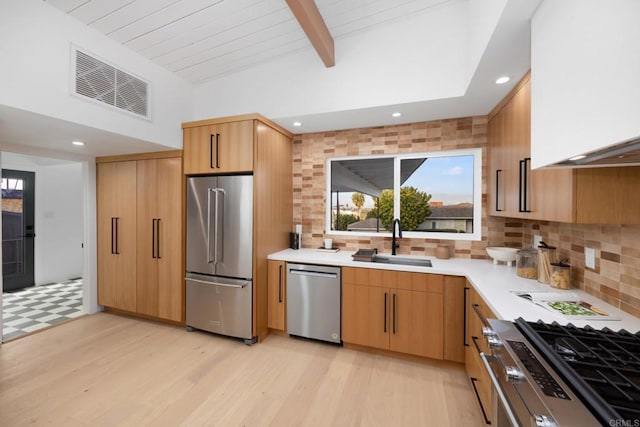 kitchen featuring tasteful backsplash, sink, light hardwood / wood-style floors, stainless steel appliances, and light brown cabinets