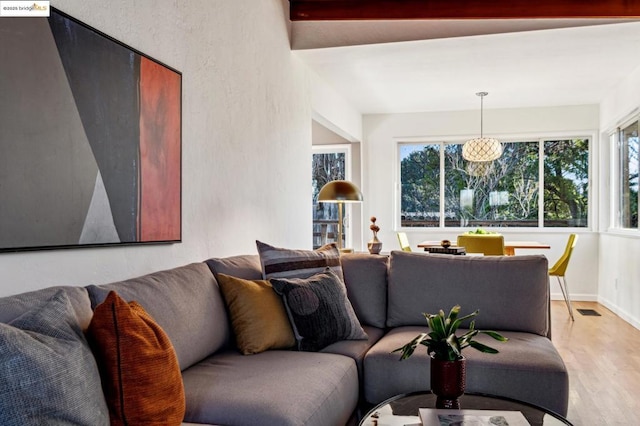 living room with light hardwood / wood-style flooring and beamed ceiling