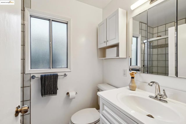 bathroom with walk in shower, vanity, and toilet