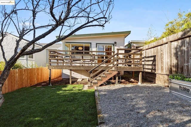 back of house featuring a yard and a deck