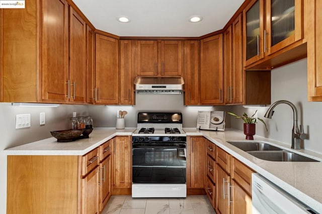 kitchen featuring light stone counters, white appliances, and sink