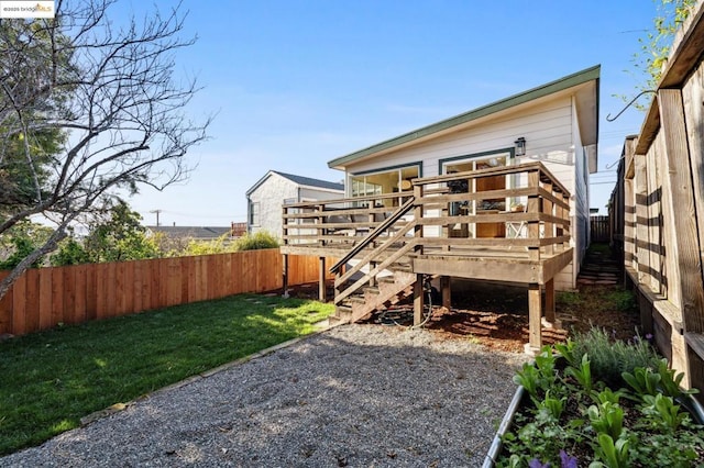 back of house with a wooden deck and a yard