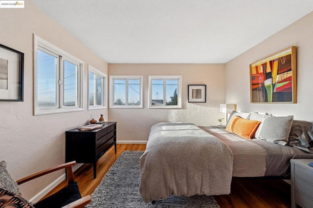 bedroom with wood-type flooring and multiple windows