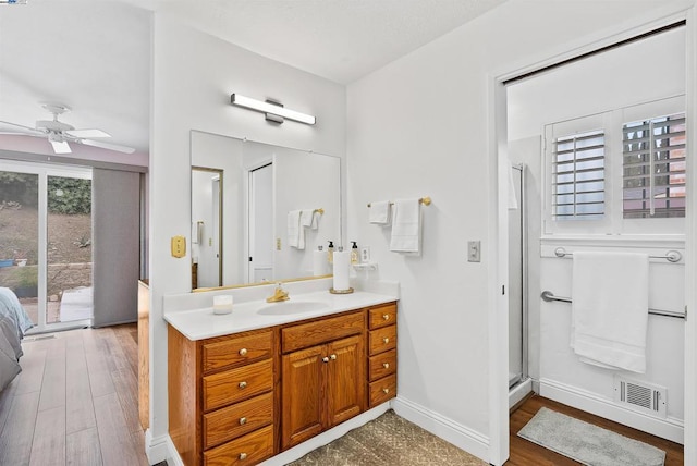 bathroom with vanity, hardwood / wood-style floors, ceiling fan, and a shower with shower door