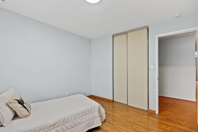 bedroom with wood-type flooring and a closet