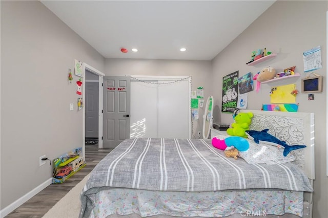 bedroom with dark hardwood / wood-style flooring and a closet