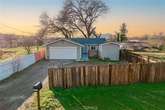 ranch-style house featuring a garage and a yard