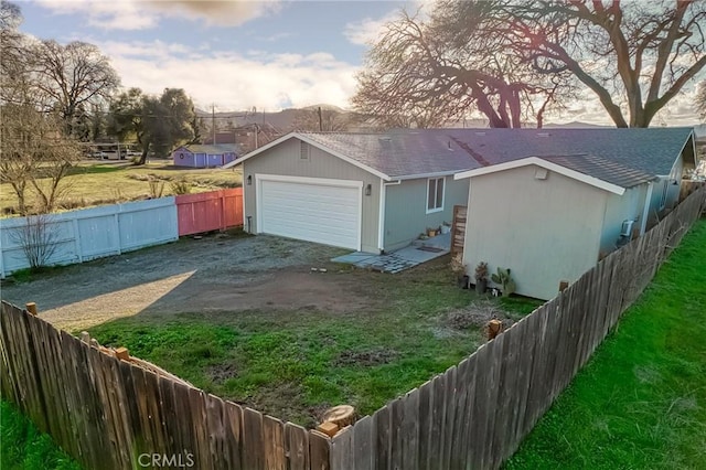 exterior space with a garage and a lawn