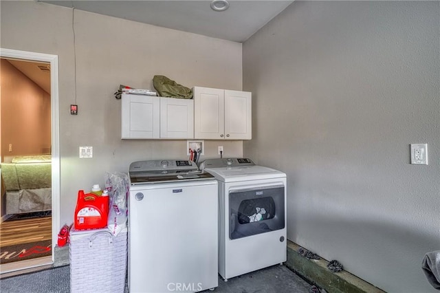 laundry area featuring washing machine and dryer and cabinets