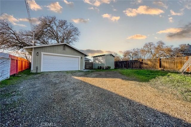 exterior space featuring a garage, an outbuilding, and a lawn