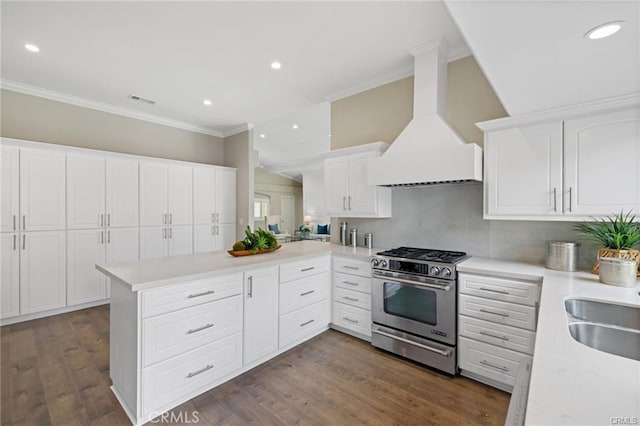 kitchen featuring premium range hood, white cabinets, dark hardwood / wood-style flooring, kitchen peninsula, and gas stove