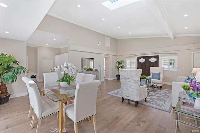 dining space featuring ornamental molding, a skylight, and light hardwood / wood-style floors