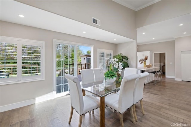 dining space featuring crown molding and light wood-type flooring