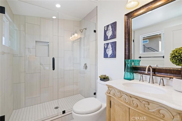 bathroom with vanity, a shower with shower door, and toilet