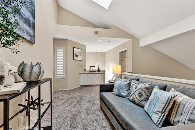 carpeted living room featuring vaulted ceiling with skylight