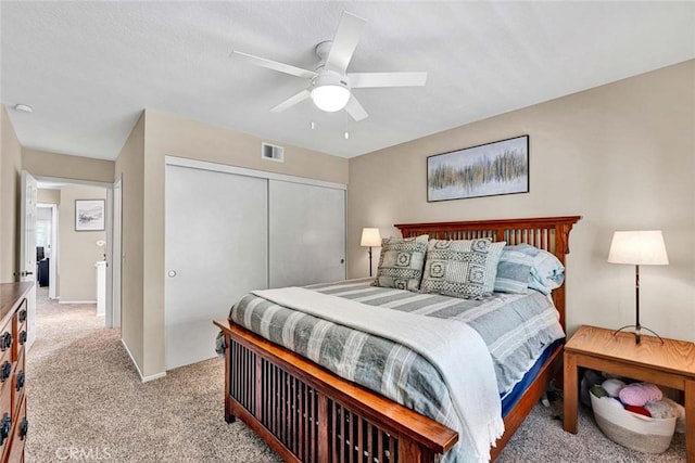 bedroom with ceiling fan, a closet, and light carpet