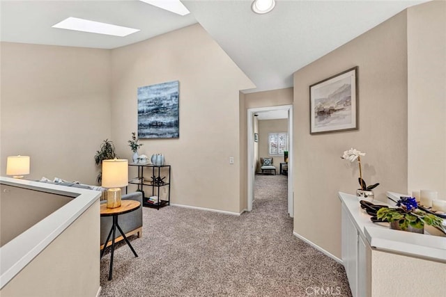 interior space featuring lofted ceiling with skylight and light carpet