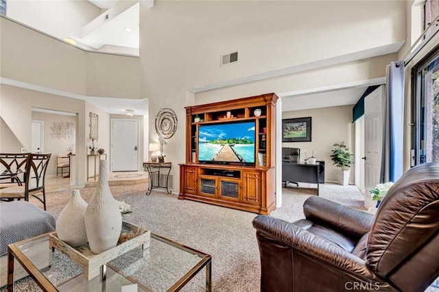 carpeted living room with a towering ceiling