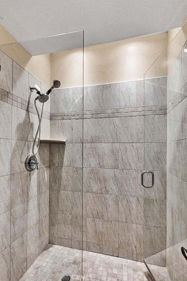 bathroom with an enclosed shower and a textured ceiling