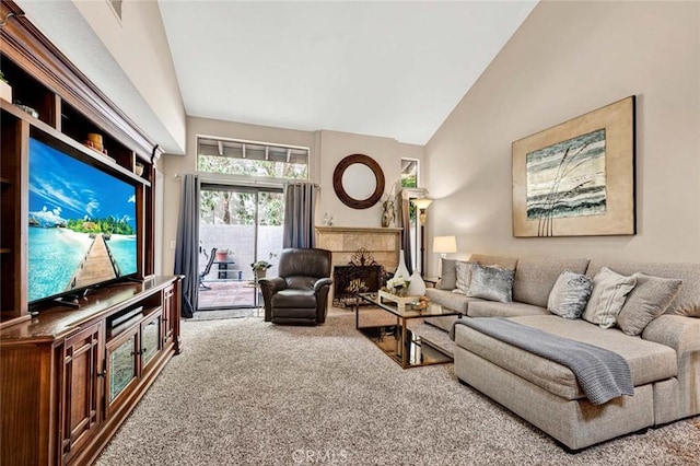 living room with a tiled fireplace, high vaulted ceiling, and carpet flooring