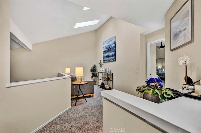 hall featuring lofted ceiling with skylight and carpet floors