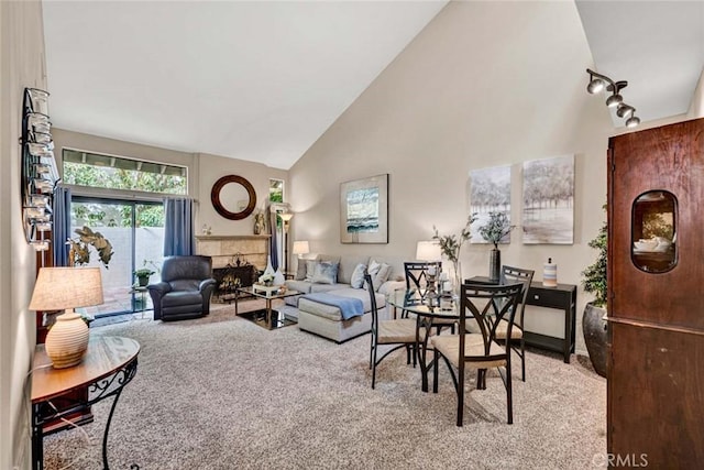 carpeted living room featuring high vaulted ceiling and a fireplace