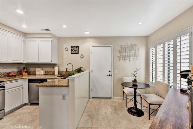 kitchen featuring sink, stainless steel dishwasher, kitchen peninsula, dark stone counters, and white cabinets