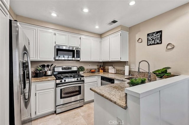 kitchen with sink, appliances with stainless steel finishes, white cabinetry, light stone countertops, and kitchen peninsula