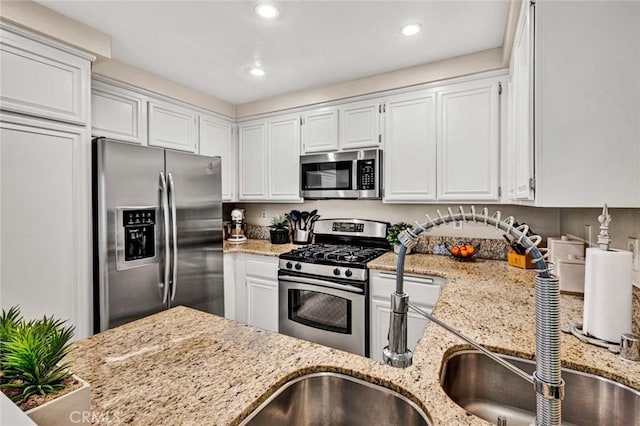 kitchen with white cabinetry, light stone countertops, and appliances with stainless steel finishes