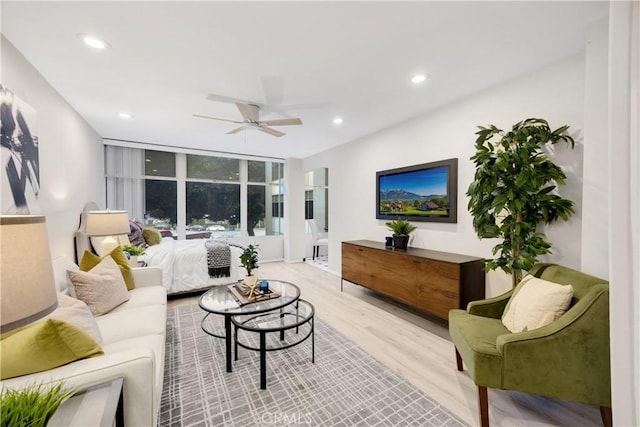 living room with ceiling fan and light hardwood / wood-style floors