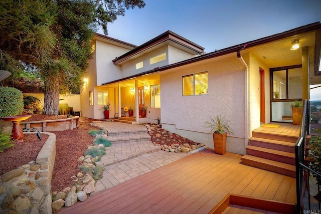 back house at dusk featuring a patio