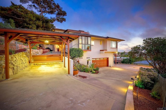 exterior space featuring a garage, concrete driveway, and stucco siding