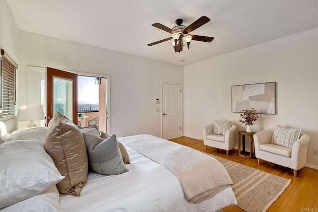 bedroom with a ceiling fan, access to exterior, and wood finished floors