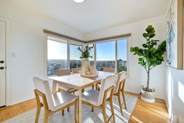 dining room with light wood-type flooring and baseboards