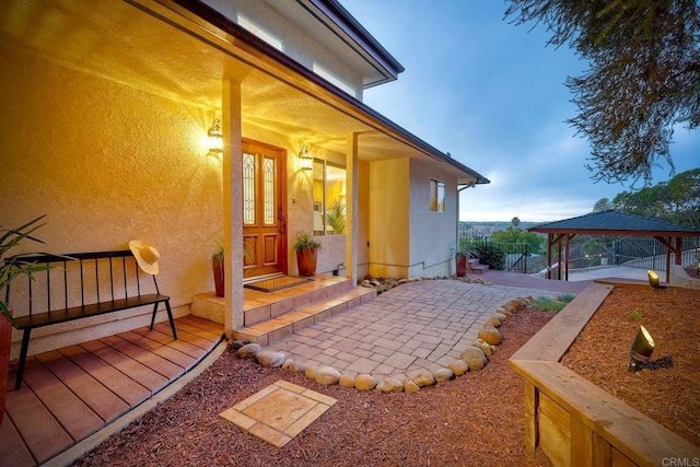 doorway to property featuring fence and stucco siding