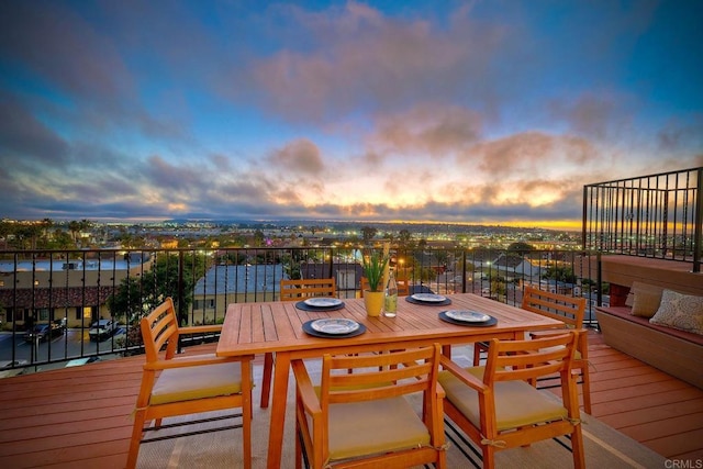 deck at dusk featuring a water view