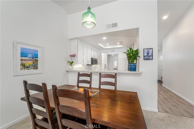 dining area with sink and light hardwood / wood-style floors