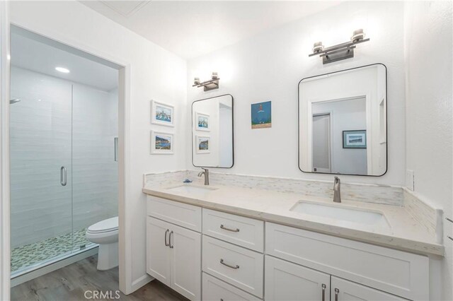 bathroom featuring hardwood / wood-style flooring, vanity, toilet, and an enclosed shower