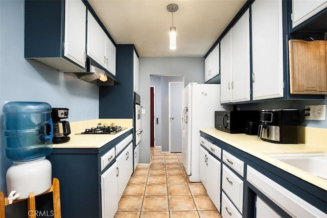 kitchen featuring pendant lighting, light tile patterned floors, white appliances, and white cabinets