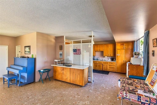 kitchen with a breakfast bar, a textured ceiling, and kitchen peninsula