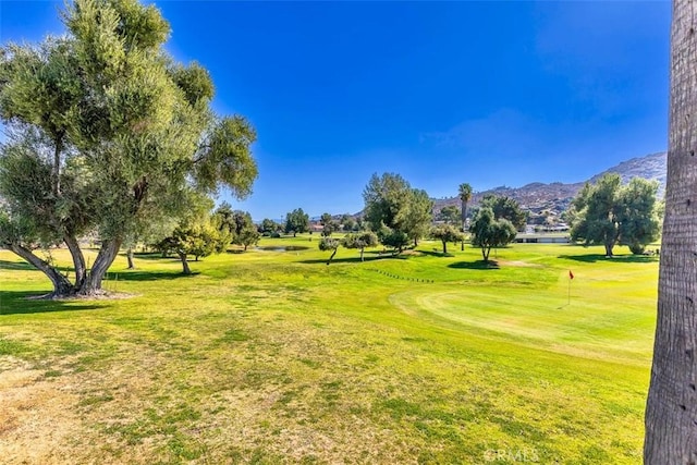 surrounding community featuring a mountain view and a lawn