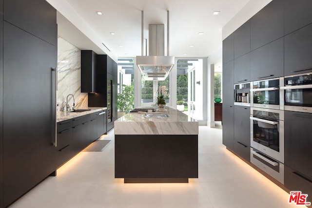 kitchen with a healthy amount of sunlight, a center island, sink, and backsplash