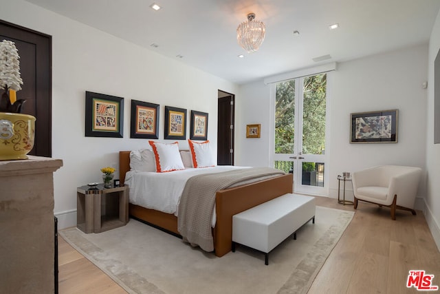 bedroom with french doors and light hardwood / wood-style flooring