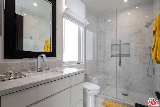 bathroom with a shower with door, vanity, and toilet