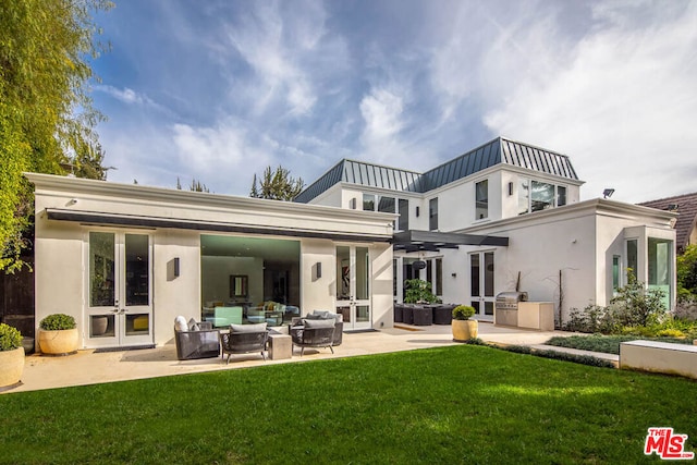 rear view of property with a lawn, french doors, and a patio area