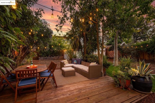 deck at dusk with an outdoor living space