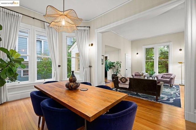 dining area featuring ornamental molding and light hardwood / wood-style flooring