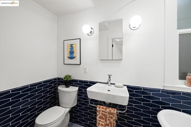 bathroom featuring tile walls, sink, and toilet