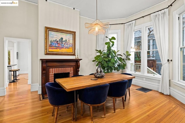 dining space with a fireplace and light wood-type flooring