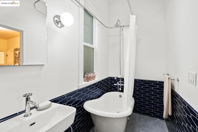 bathroom featuring sink, tile walls, a washtub, and tile patterned floors